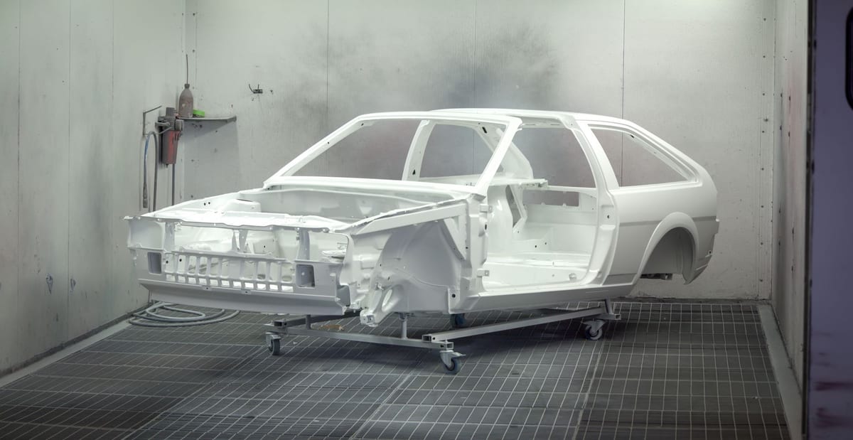 A vehicle body freshly primed inside an automotive paint booth